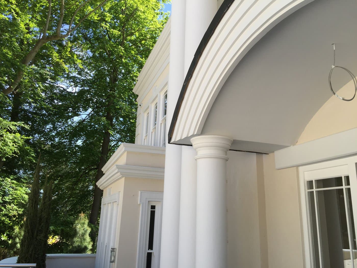 Close view of a portico column beside the curved entrance moulding at the St George’s Hill residence.