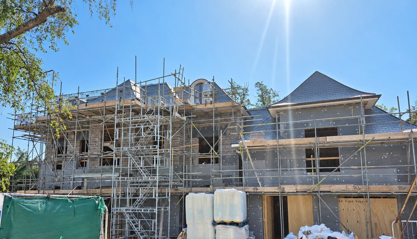 House behind scaffolding with grey graphite insulation boards fixed to the walls