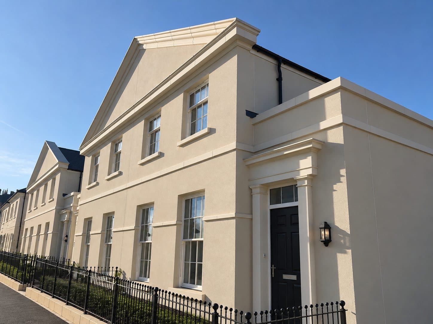 Cream rendered townhouse with a pediment and door surround