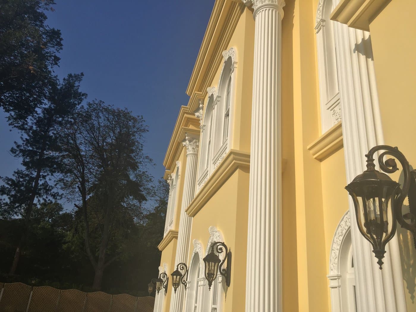 Row of full-height fluted columns aligned with window surrounds and string bands on the Surrey residence.