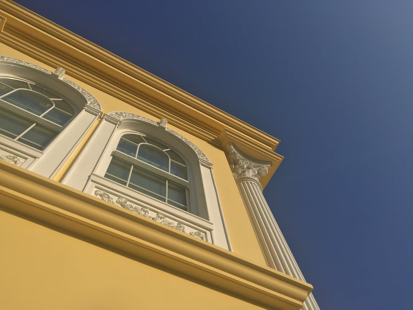 Arched window surround and decorative panel beside a fluted column.